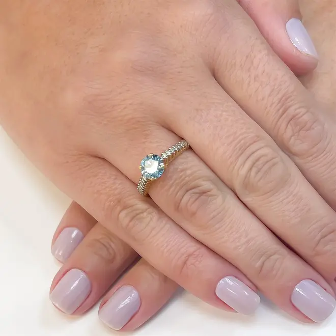 Anel Solirário de Ouro Amarelo com Diamantes Laterais e Diamante Azul Central  de 1,05 Cts.