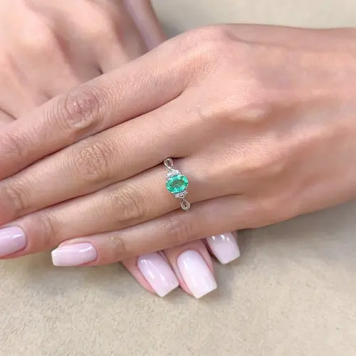 Anel Infinito de Ouro Branco com Diamantes e Esmeralda de 80 pts.