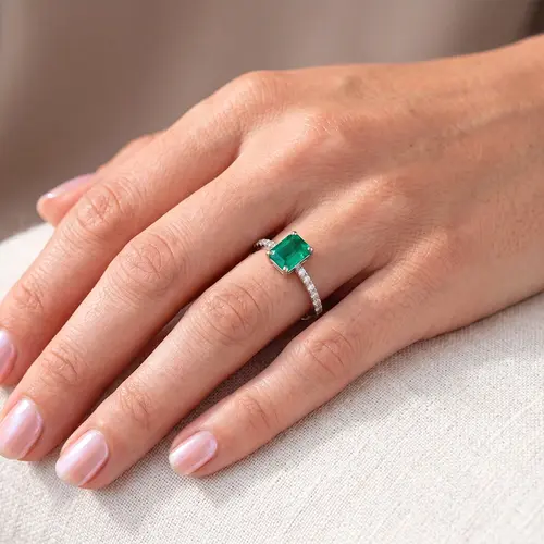 Anel de Ouro Branco com 16 Diamantes e Esmeralda de 8 Pts.
