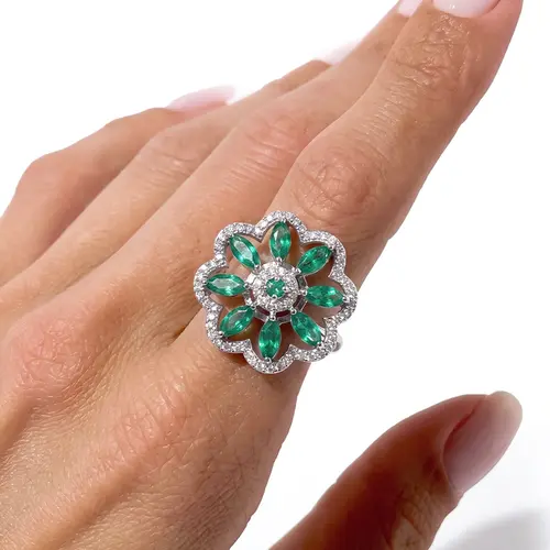 Anel Flor de Ouro Branco com 60 Diamantes e Esmeraldas.
